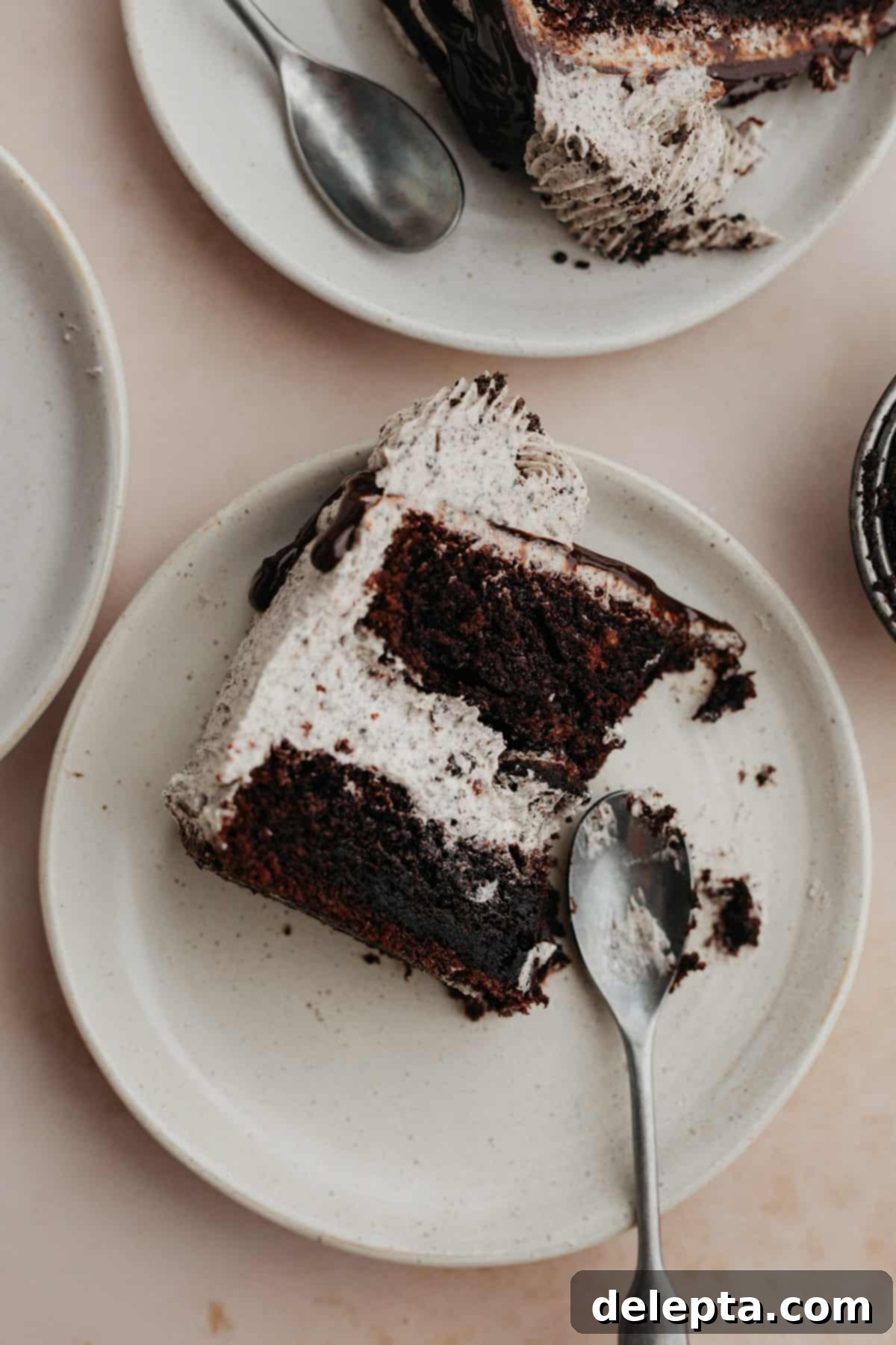 Decadent Oreo Drip Cake 18 Three plates of Oreo drip cake slices on them, showcasing the layers