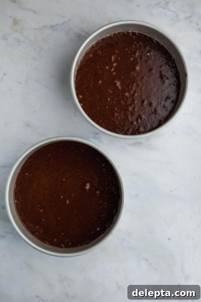 Decadent Oreo Drip Cake 7 Two cake pans with unbaked chocolate cakes, ready for the oven
