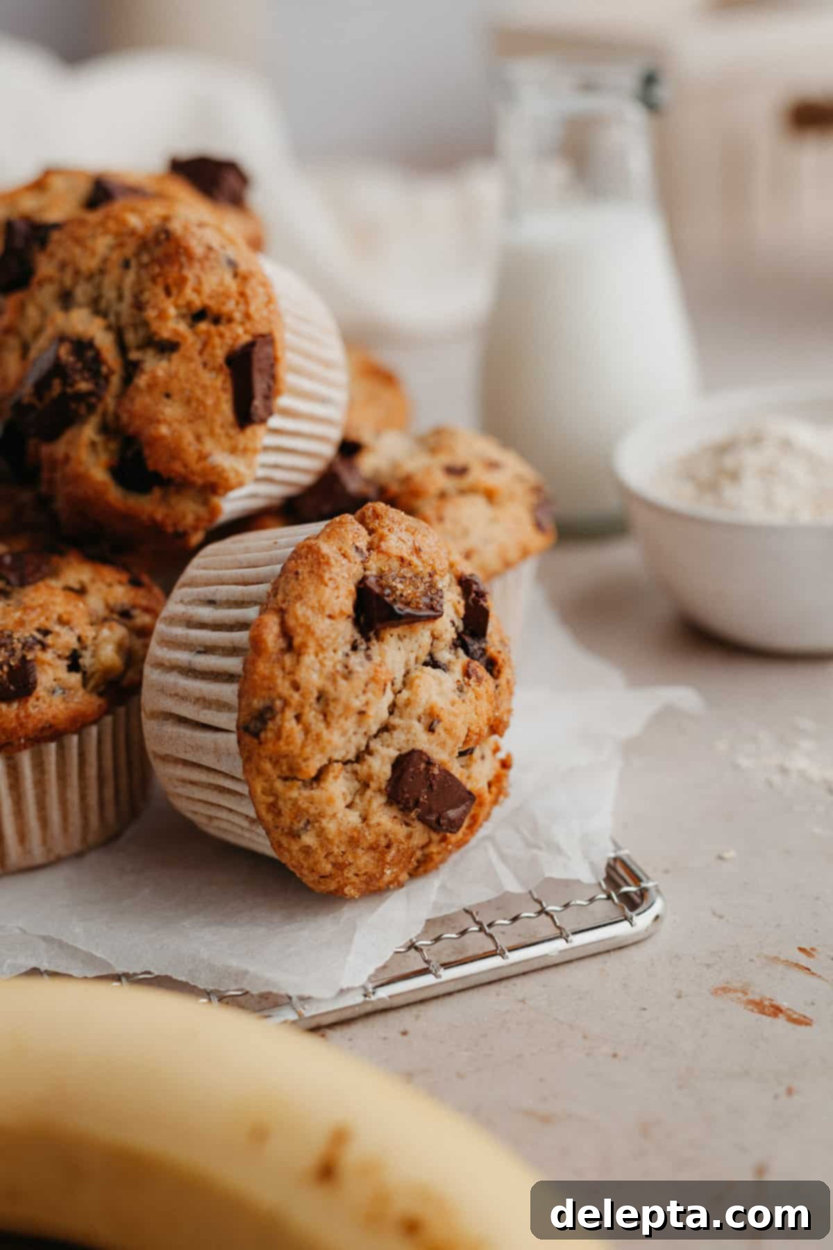 Irresistible Chocolate Chip Peanut Butter Muffins 11 A beautiful pile of chocolate chunk muffins arranged on a wire cooling rack, showcasing their fluffy texture and golden-brown tops.