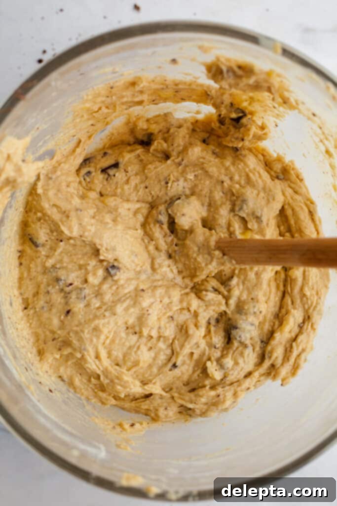 Irresistible Chocolate Chip Peanut Butter Muffins 8 A glass mixing bowl with peanut butter banana muffin batter, just after chocolate chunks have been folded in.