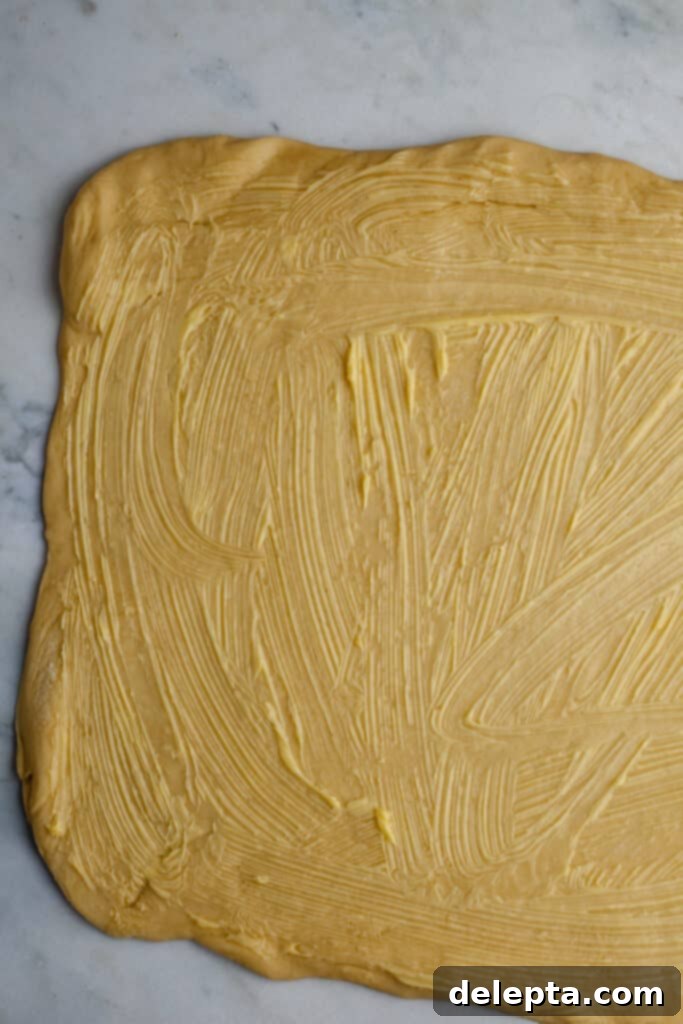 Pillowy Swedish Cinnamon Swirls 11 Rolled out Swedish cinnamon bun dough, generously covered with softened unsalted butter all the way to the edges, creating a sticky base for the filling.