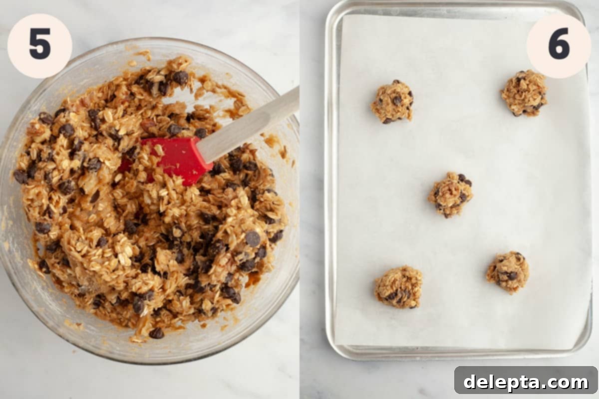 Irresistible Oatmeal Walnut Chocolate Chip Cookies 6 A glass bowl with ready cookie dough and a baking sheet featuring five perfectly portioned cookie dough balls, ready to be baked into delicious oatmeal chocolate chip cookies.