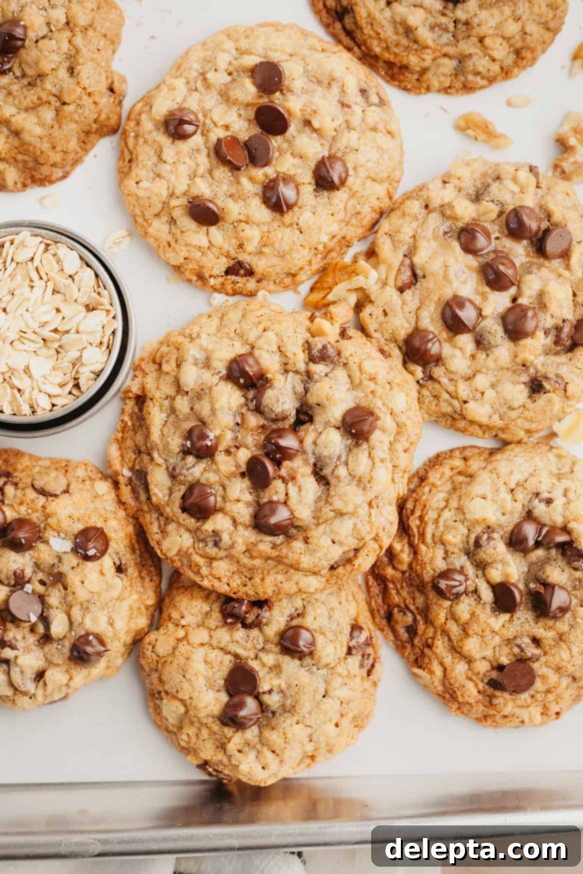 Irresistible Oatmeal Walnut Chocolate Chip Cookies 8 A baking sheet filled with freshly baked oatmeal chocolate chip cookies, glistening and perfectly golden, cooling after coming out of the oven.