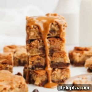 Easy One Bowl Brown Butter Biscoff Blondies 10 A stack of golden brown Biscoff blondies, with melted cookie butter oozing delightfully down the sides, ready to be enjoyed.