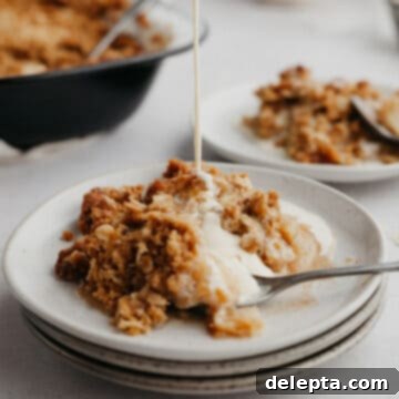 Warm Apple Crumble with Custard 11 A stack of small grey plates, the top one has apple crumble on it and there is custard being poured on it