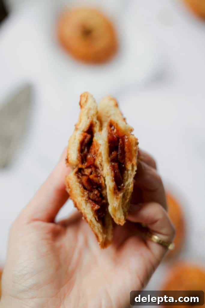 Honey-Kissed Apple Hand Pies 4 A close-up shot of a hand pie cut open, revealing the warm, caramelized apple and honey filling inside