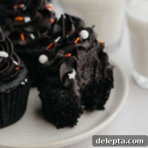 Midnight Velvet Delights 10 A black velvet cupcake with a bite taken out of it.