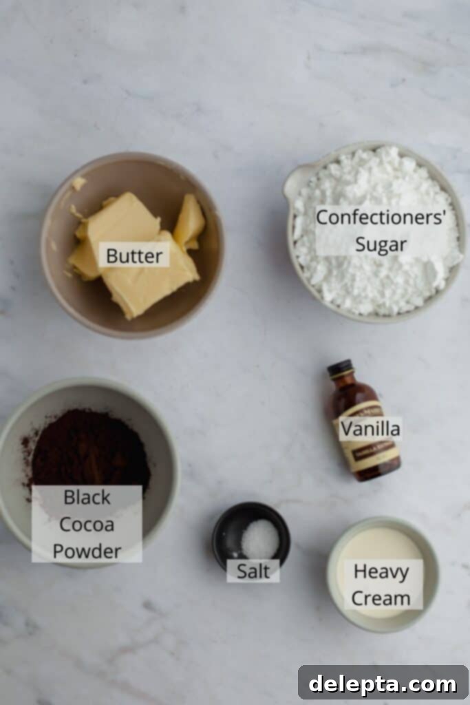 Midnight Velvet Delights 4 ingredients for black velvet frosting measured out in small bowls on a marble counter.