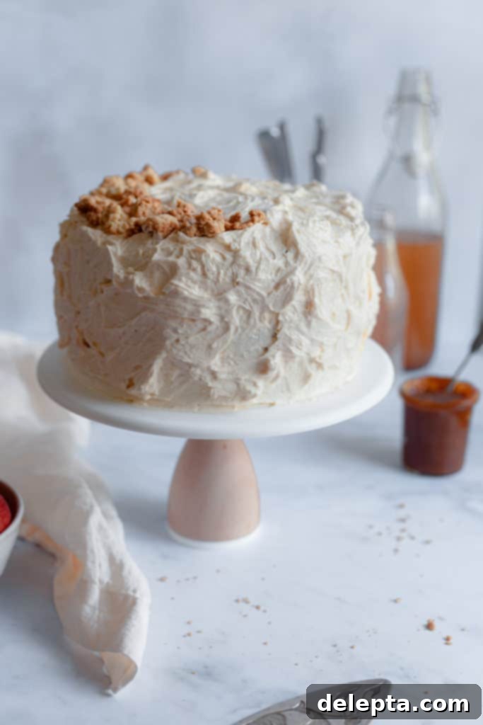 Salted Caramel Apple Cider Layer Cake with Pie Crumb Frosting 3 A beautifully decorated apple cider layer cake sitting on a white cake stand, ready to be served, capturing the essence of fall baking.