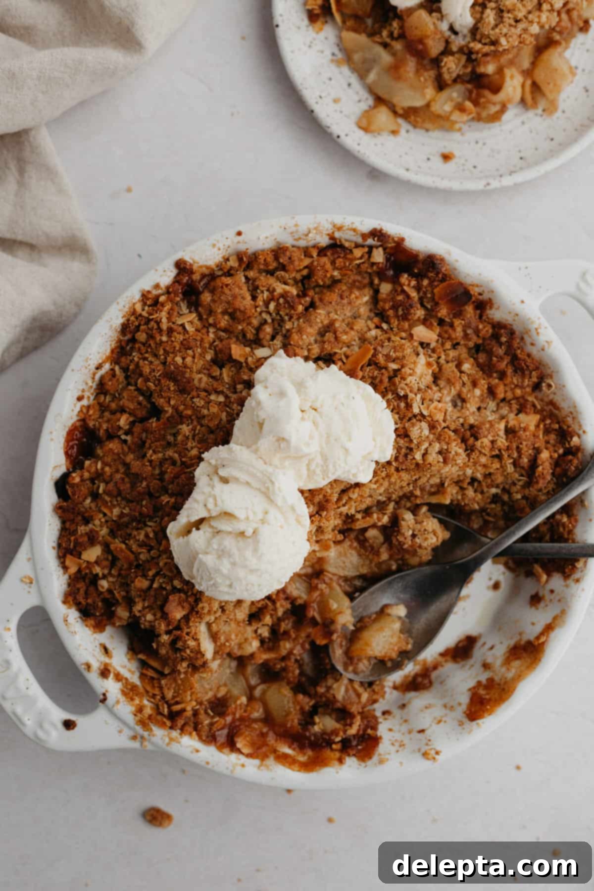 Ginger-Kissed Harvest Apple & Pear Crisp 2 A round white ceramic dish with a perfectly baked pear and apple crisp, golden brown and bubbling.