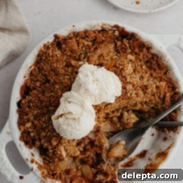 Ginger-Kissed Harvest Apple & Pear Crisp 9 A round white ceramic dish with pear and apple crisp.