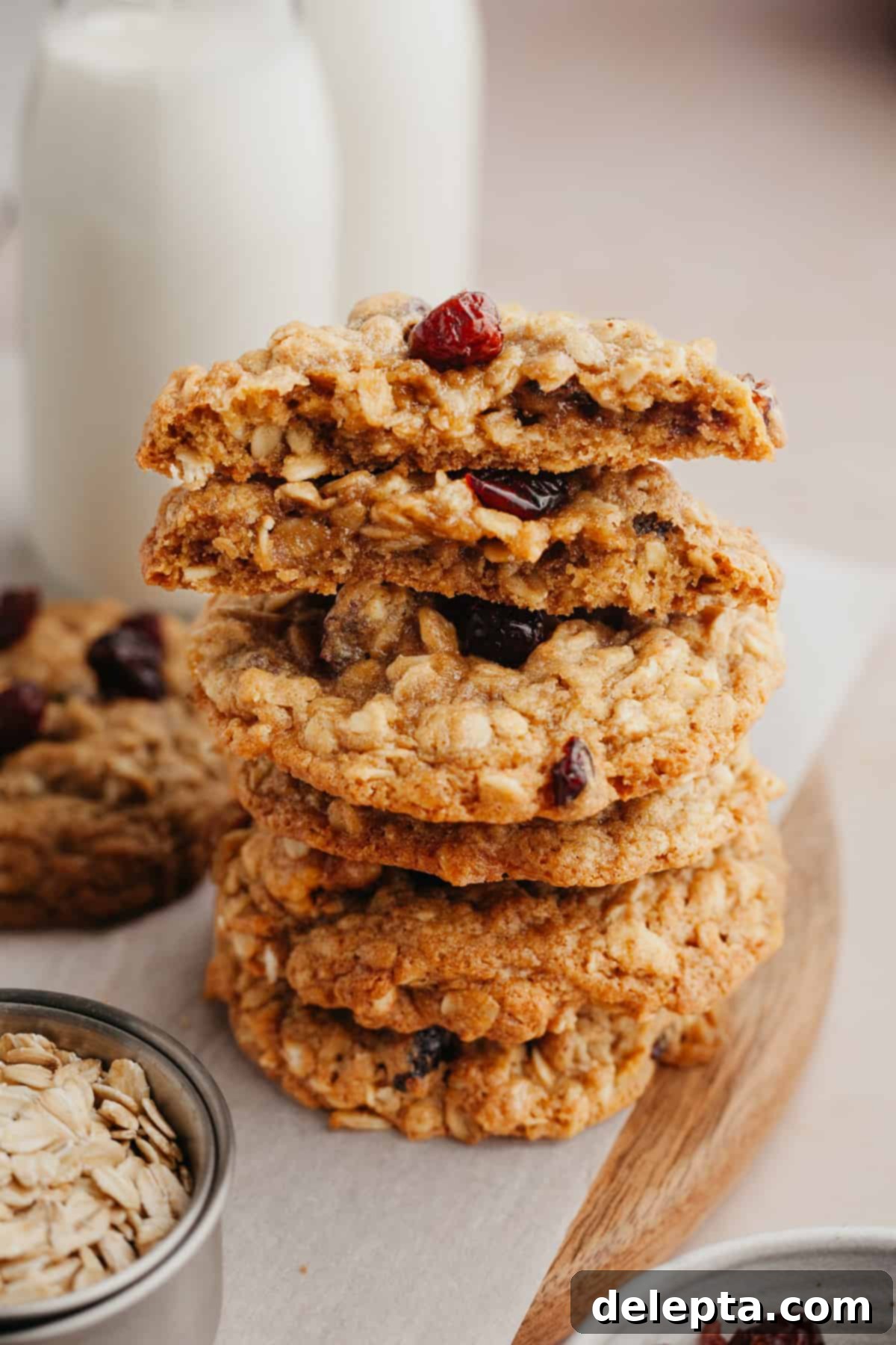 Wholesome Cranberry Walnut Oat Cookies 2 A stack of golden brown, soft, and chewy oatmeal cranberry walnut cookies on a cooling rack.