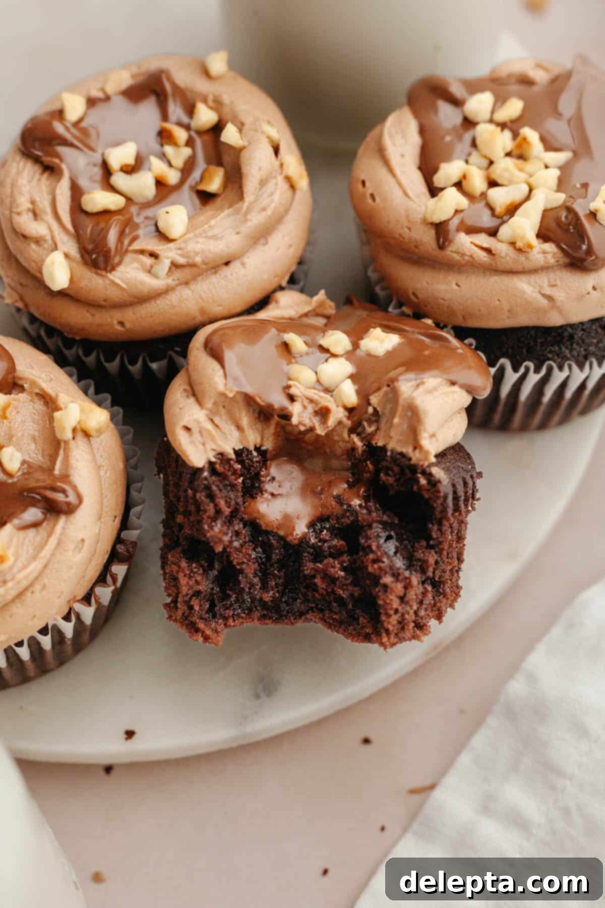 Quick Nutella-Stuffed Cupcakes 2 A chocolate cupcake with a bite taken out of it showing it's filled with chocolate.