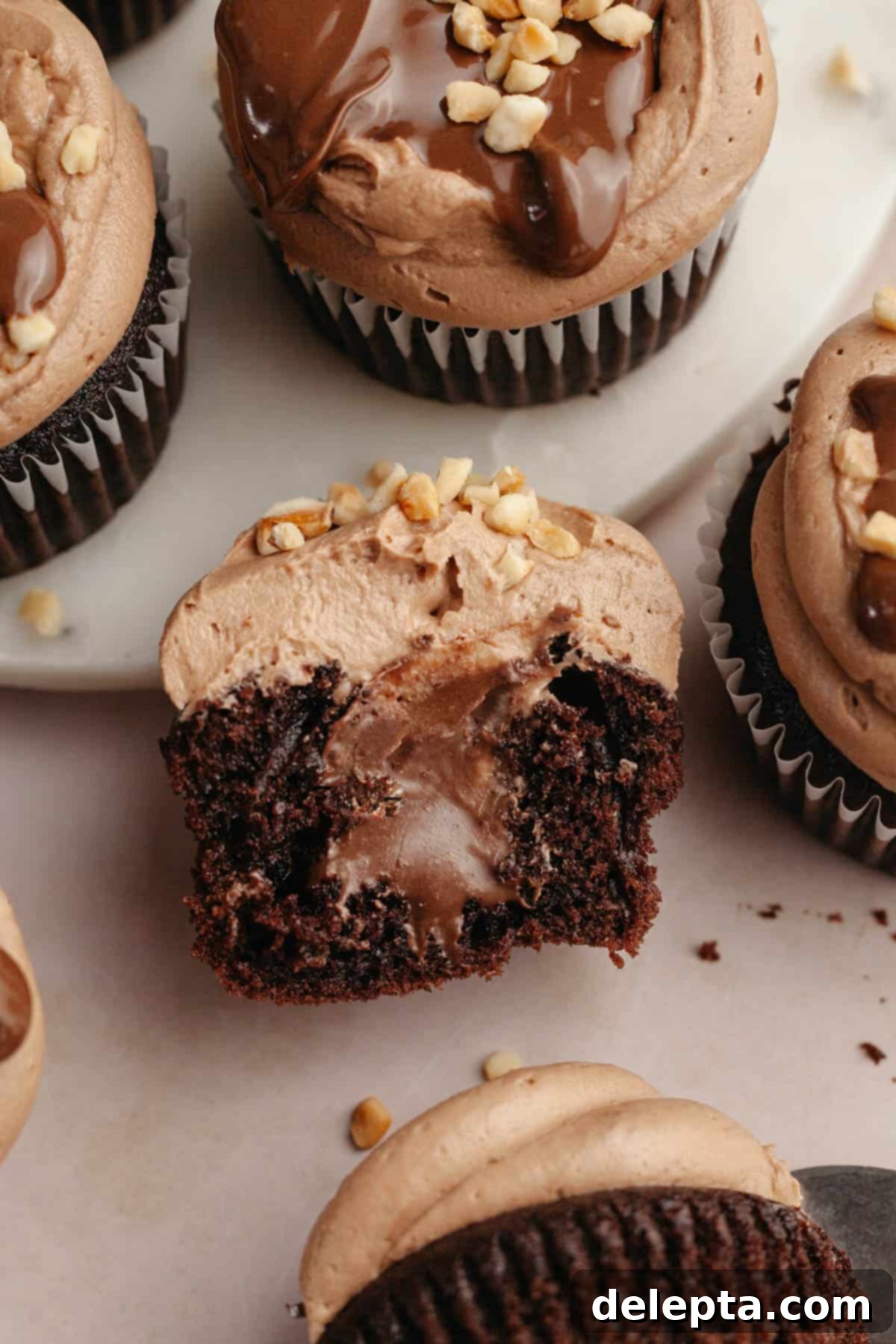 Quick Nutella-Stuffed Cupcakes 11 A chocolate cupcake sliced in half, showing it has a chocolate center.