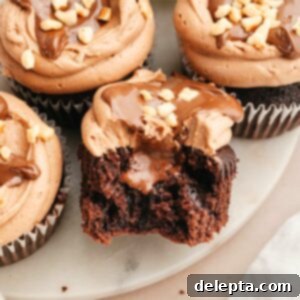 Quick Nutella-Stuffed Cupcakes 12 A chocolate cupcake with a bite taken out of it showing it's filled with chocolate.