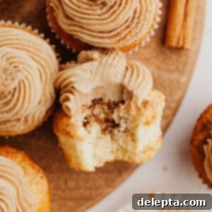 Spiced Cinnamon Cupcakes with Golden Brown Sugar Buttercream 11 A cinnamon cupcake with a bite taken out of it, showing the moist crumb and creamy frosting.