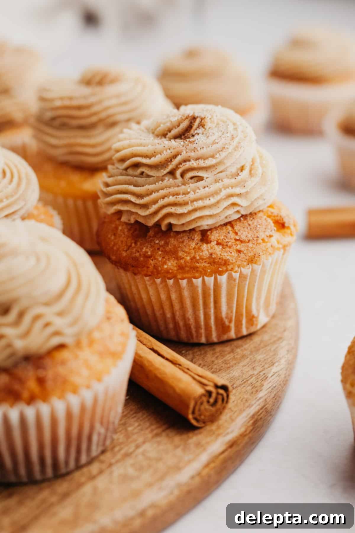Spiced Cinnamon Cupcakes with Golden Brown Sugar Buttercream 9 Cinnamon sugar cupcakes frosted beautifully on a wooden board, ready to be enjoyed.