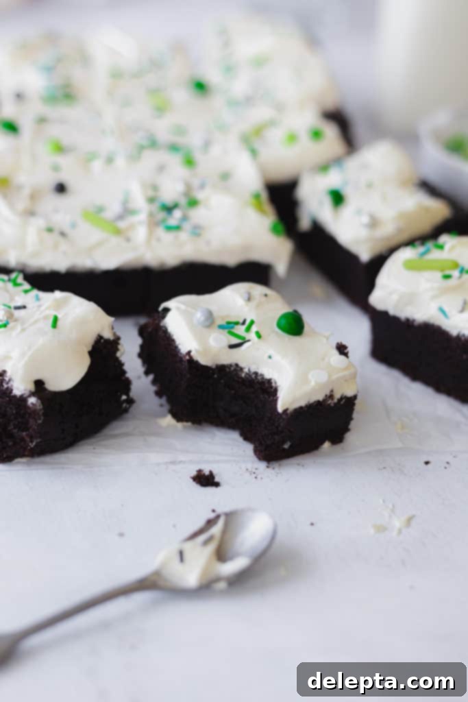 Decadent Fudgy Chocolate Sheet Cake with Sesame Cream Frosting 2 a bite taken out of one slice of chocolate cake, topped with tahini ffrosting