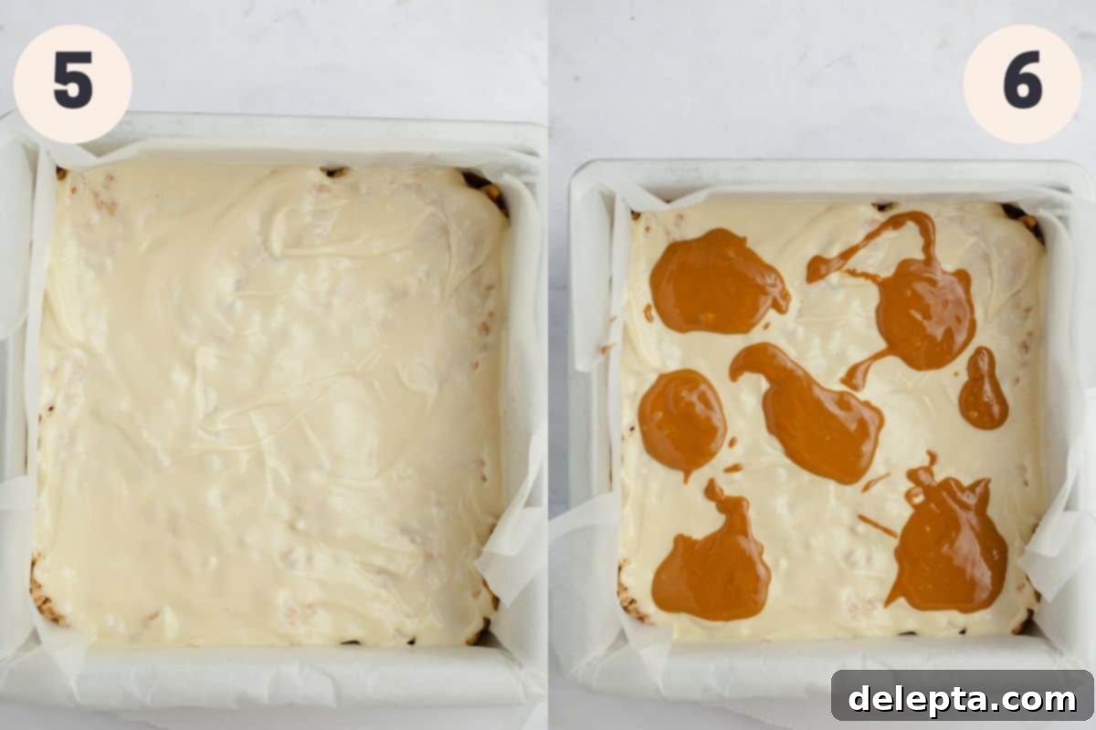 Ultimate Biscoff Krispie Bars 6 A square pan filled with rice krispie treats covered in melted white chocolate and dollops of melted Biscoff spread.