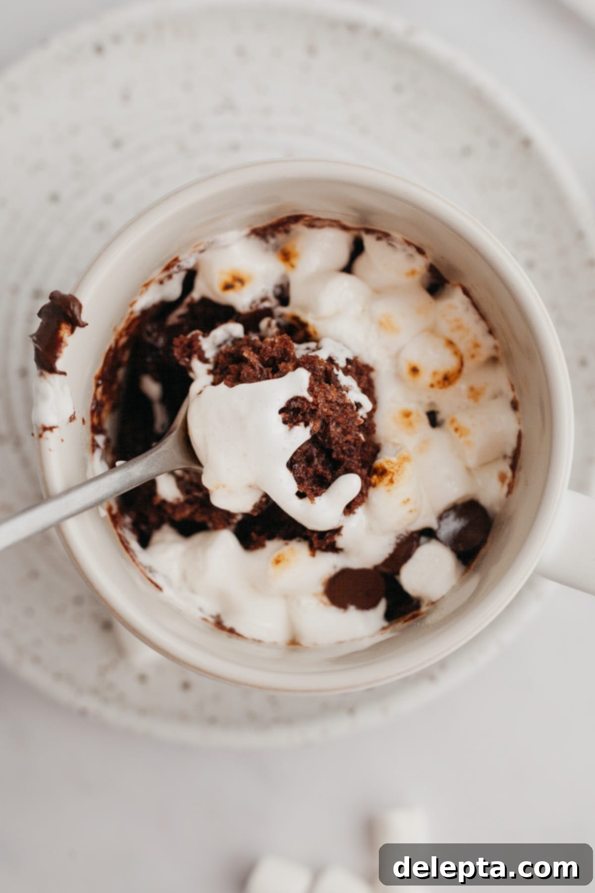 Mugful of Cocoa Bliss 5 A white mug with a chocolate mug cake topped with beautifully melted marshmallows.