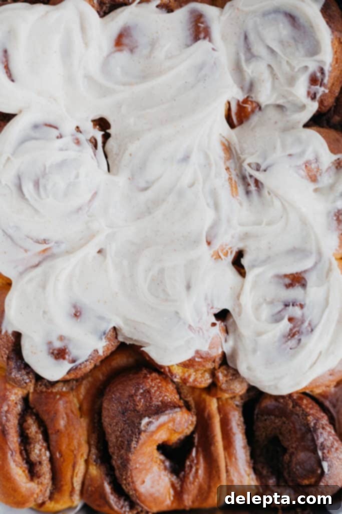 Warm Pumpkin Swirls with Brown Butter Glaze 2 overhead view of pumpkin cinnamon rolls, covered in frosting