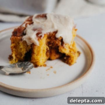 Warm Pumpkin Swirls with Brown Butter Glaze 6 one cinnamon bun on a plate with frosting