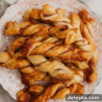 Flaky Cinnamon Twists 8 A small red and white plate with golden-brown cinnamon sugar twists on it, ready to be served.