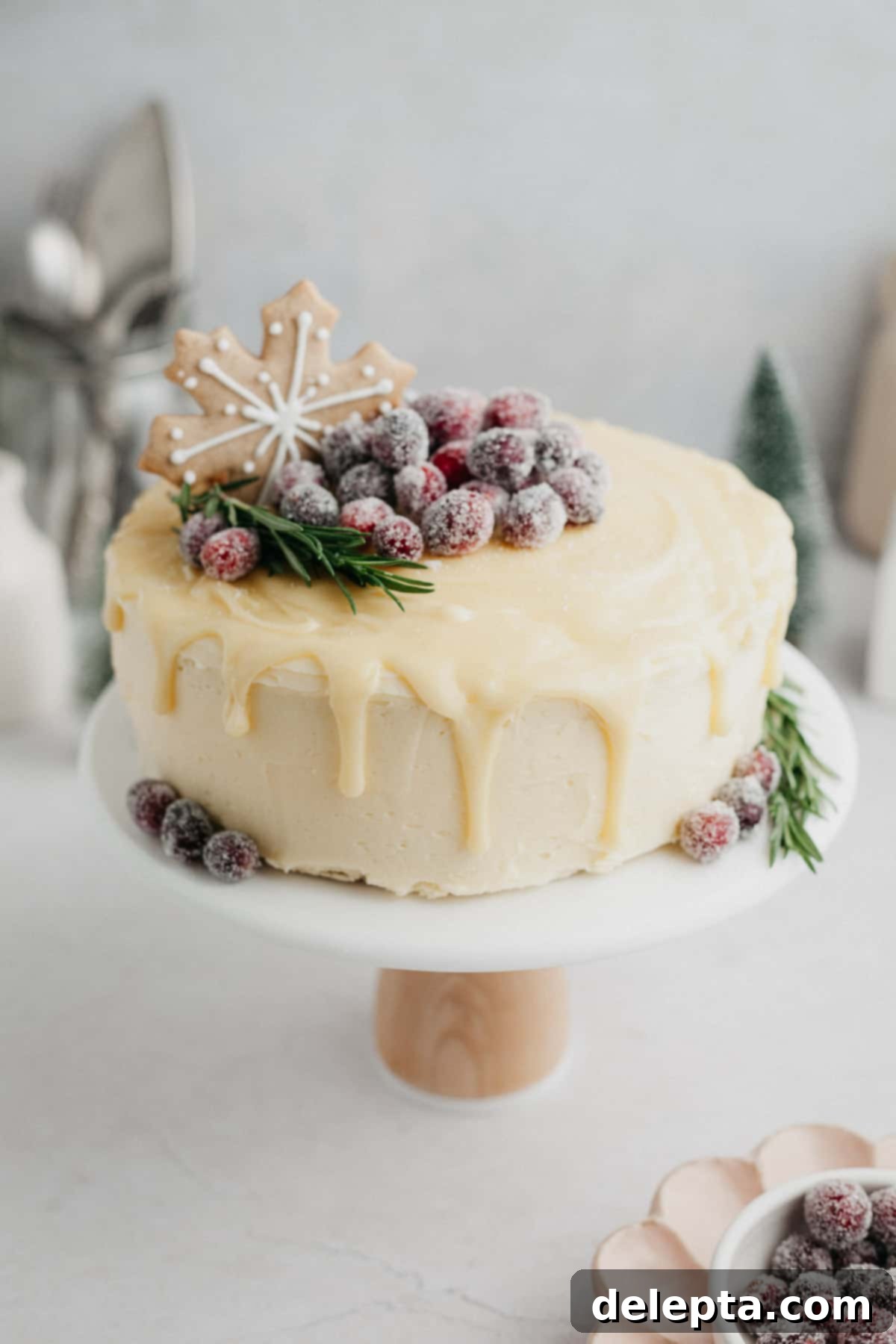 Frosted Peppermint Eggnog Drip Dream 2 A beautifully decorated white chocolate drip cake, adorned with festive gingerbread cookies and glistening sugared cranberries, perfect for the holiday season.