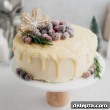 Frosted Peppermint Eggnog Drip Dream 12 A white chocolate drip cake decorated with a gingerbread cookie and sugared cranberries.