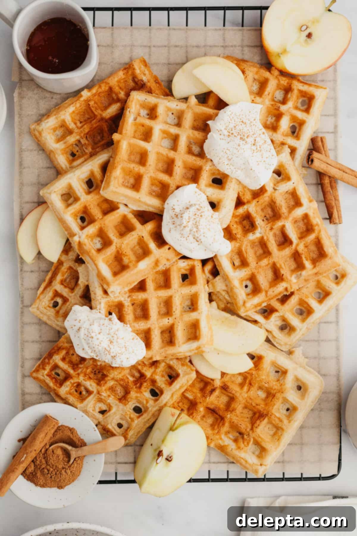 Apple Pie Waffles 2 Waffles on parchment paper, showcasing their golden-brown exterior and inviting texture.