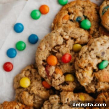 M and M Loaded Peanut Butter Oatmeal Cookies 8 Oatmeal peanut butter M&M cookies on parchment paper.