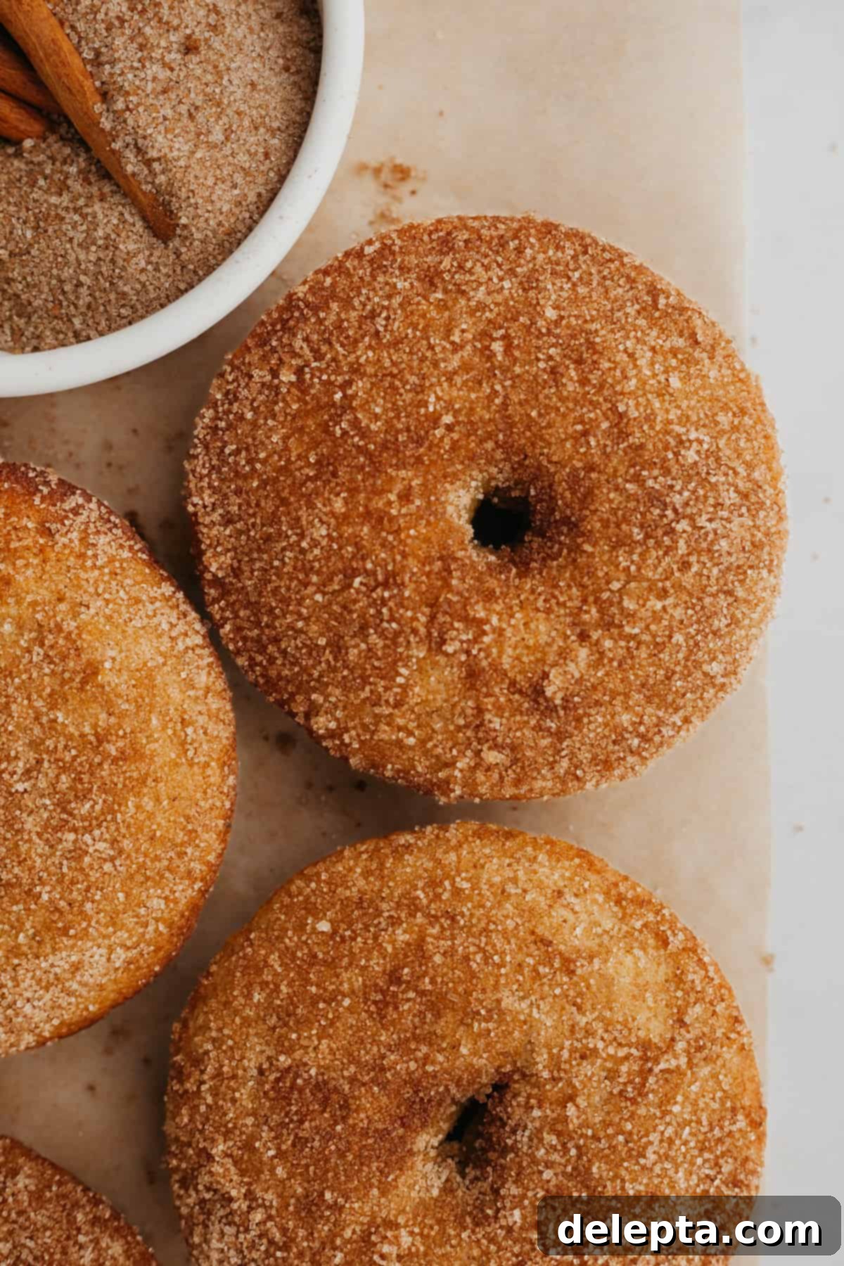 15-Minute Cinnamon Donut Magic 8 Seven delicious baked cinnamon sugar donuts piled on a white plate, ready to be served.