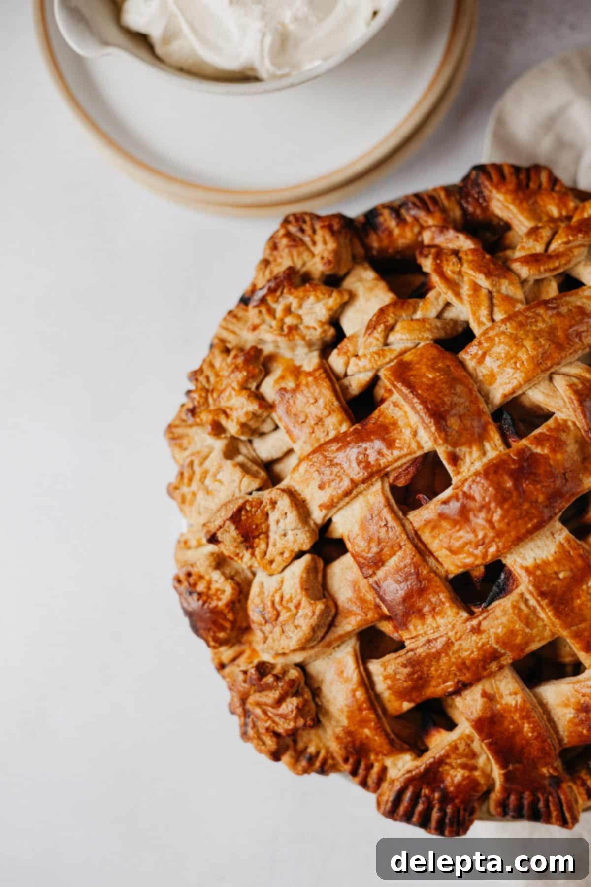Fireside Bourbon Apple Pie 16 A close-up shot of a homemade apple pie, featuring an intricate lattice top crust baked to golden perfection.