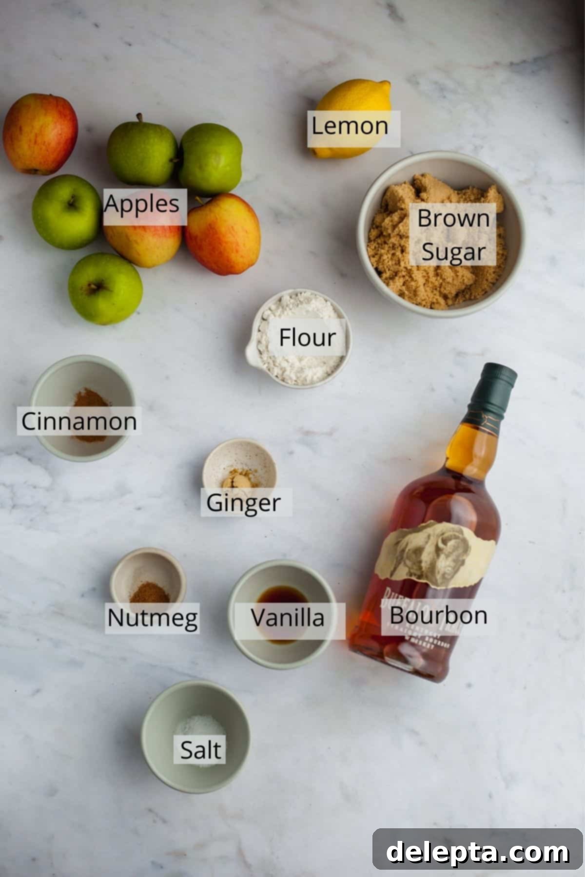 Fireside Bourbon Apple Pie 3 A collection of ingredients for bourbon apple pie filling in small glass bowls, including sliced apples, brown sugar, and spices.