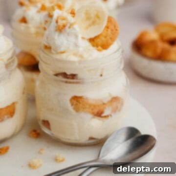 Jarred Banana Pudding Bliss 10 A close up of banana pudding in a jar on a marble surface.