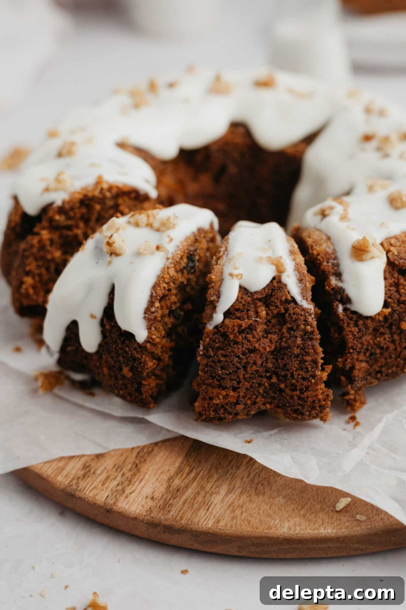 Golden Spiced Carrot Crown 6 A beautifully glazed carrot bundt cake, with several inviting slices already cut and visible, showcasing its moist interior.