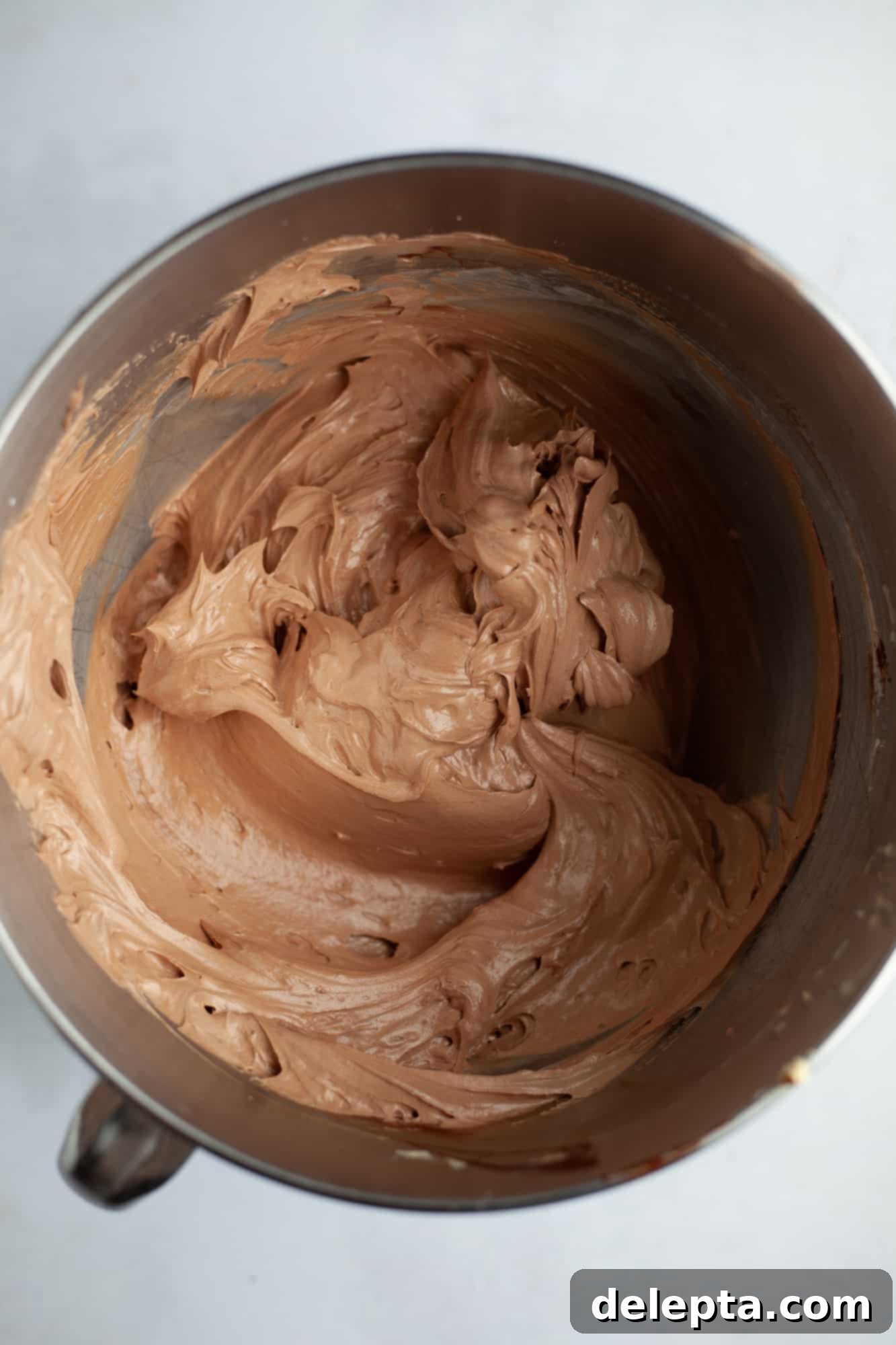 Peanut Butter Chocolate Nirvana 12 A large silver mixing bowl with chocolate frosting in it