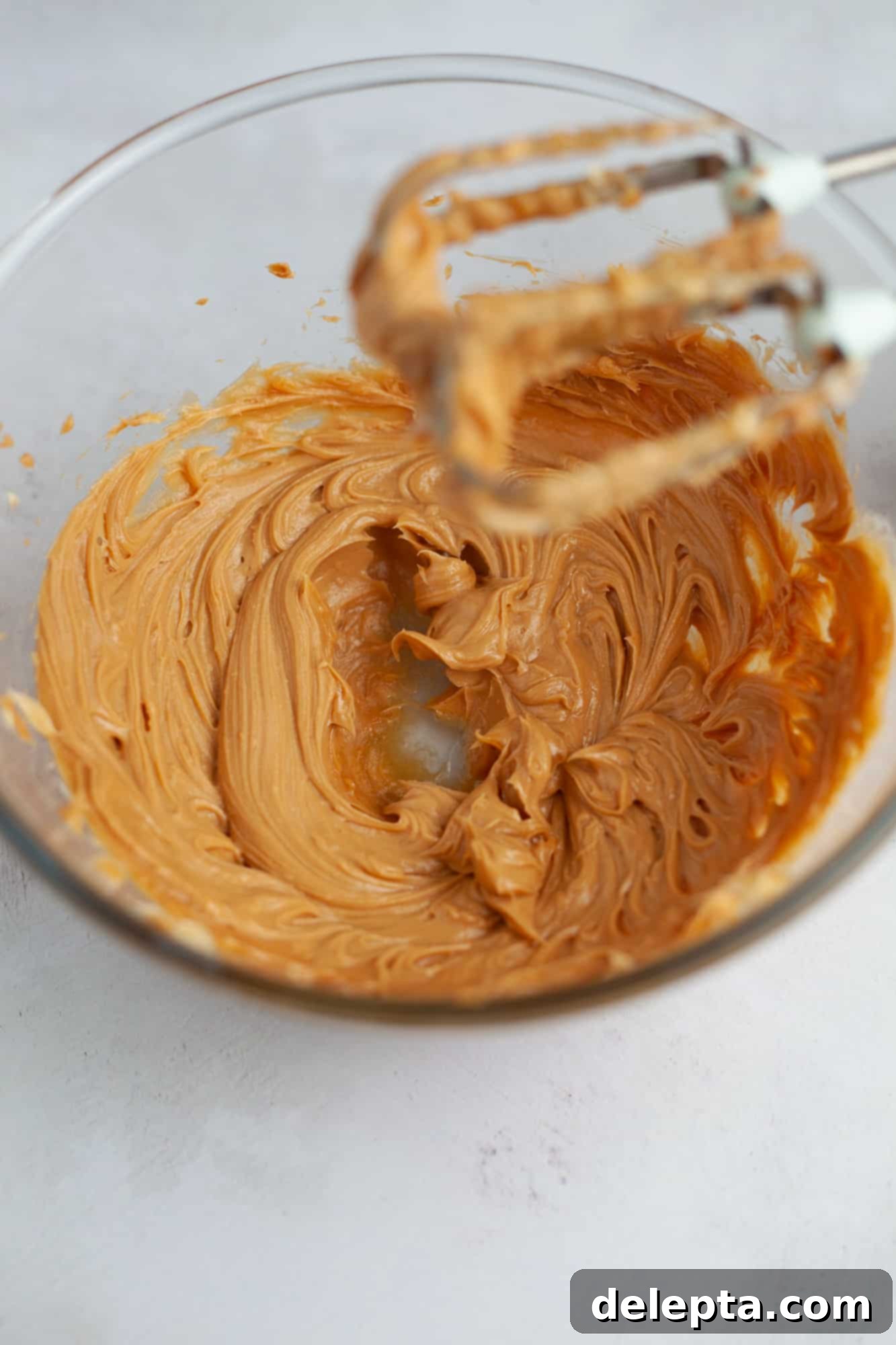 Peanut Butter Chocolate Nirvana 13 A pyrex glass bowl with whipped peanut butter in it. You can see the whisks of a handheld mixer just above it