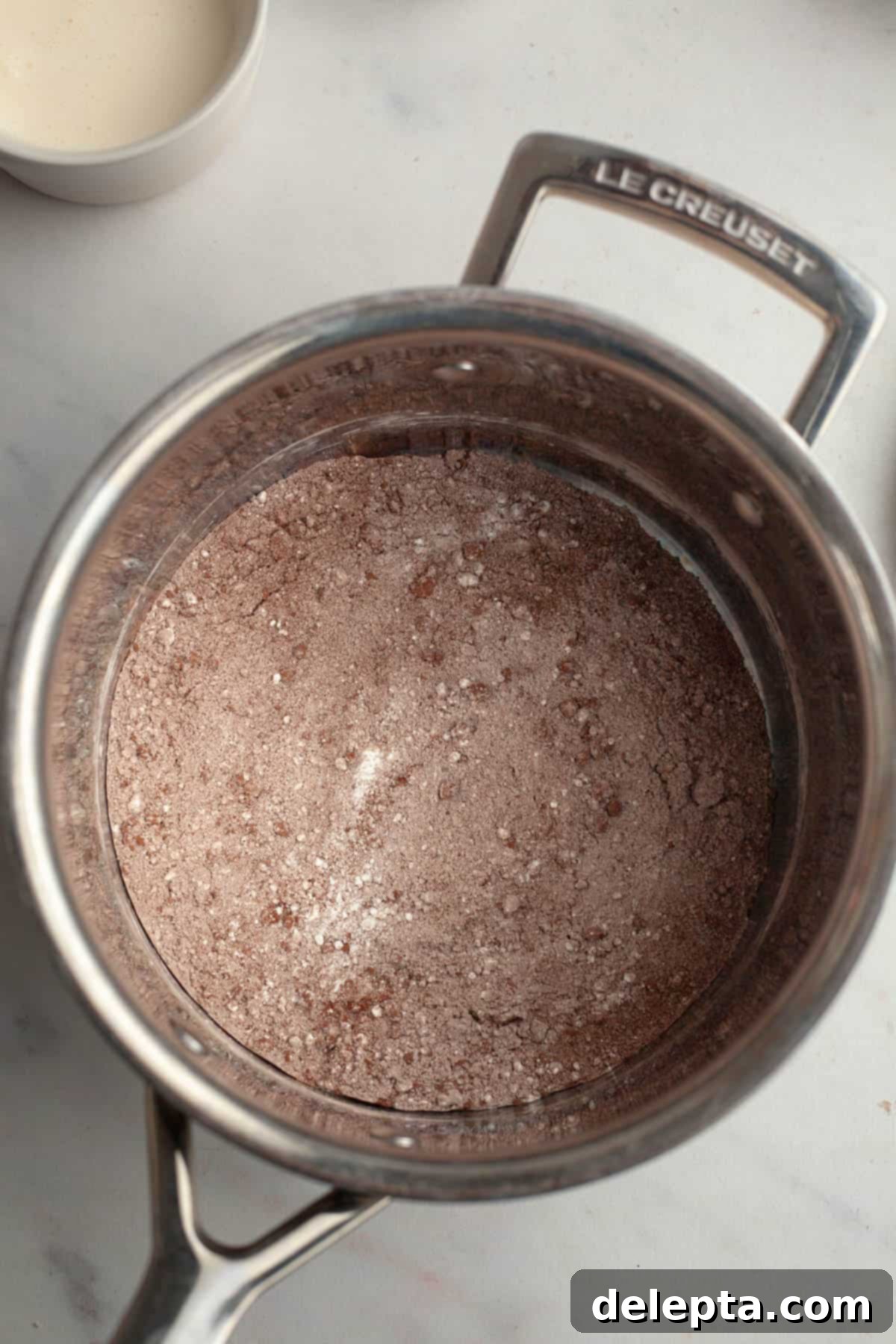Spooky Simple Homemade Chocolate Pudding Dirt Cups 4 A small saucepan with cornstarch, sugar and cocoa powder in it.