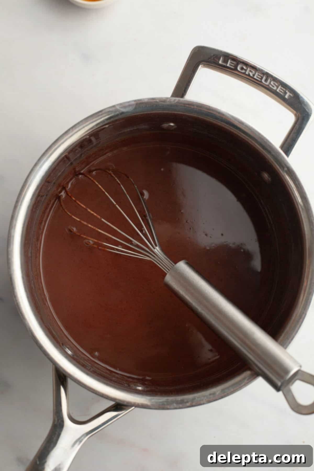 Spooky Simple Homemade Chocolate Pudding Dirt Cups 5 Chocolate pudding in a small saucepan with a whisk.
