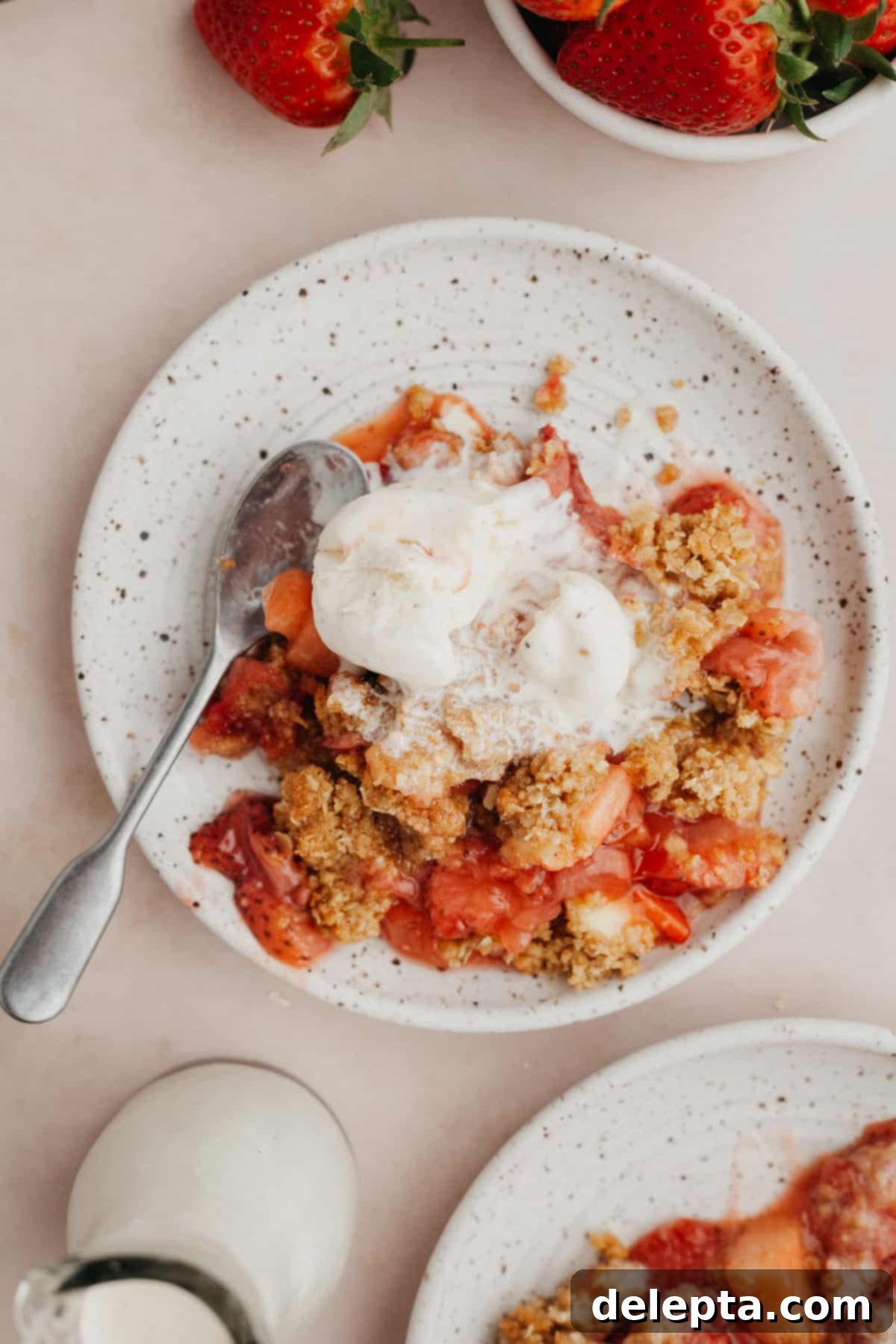 Simple Strawberry Apple Crisp 6 a small plate with strawberry crisp on it and a scoop of vanilla ice cream.