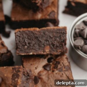Decadent Fudgy Triple Chocolate Brownies 11 A perfectly fudgy brownie showcasing its rich texture and crackle top, resting on parchment paper.