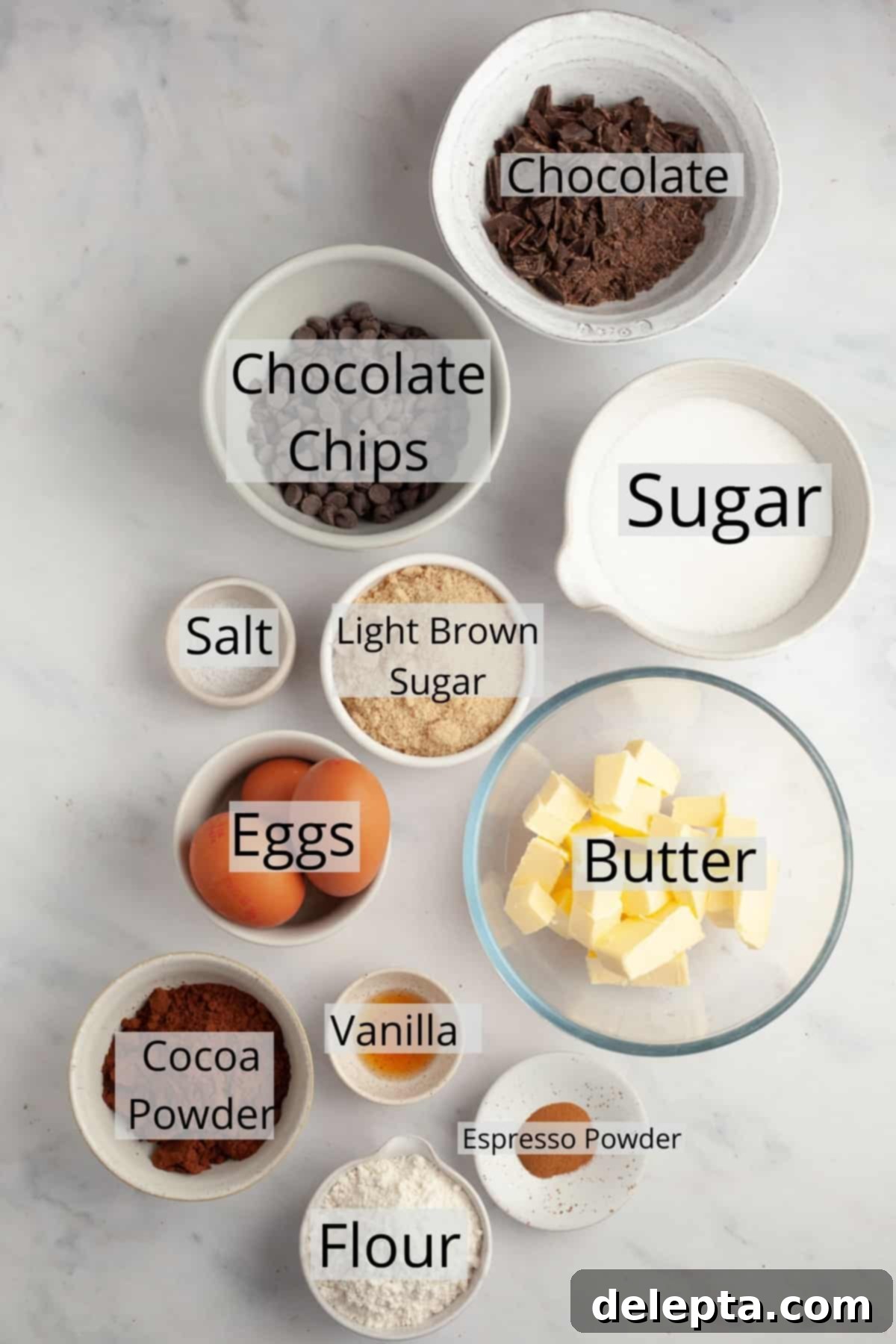 Decadent Fudgy Triple Chocolate Brownies 3 Carefully measured ingredients for triple chocolate brownies, including cocoa powder, chocolate, and butter, displayed in individual bowls.