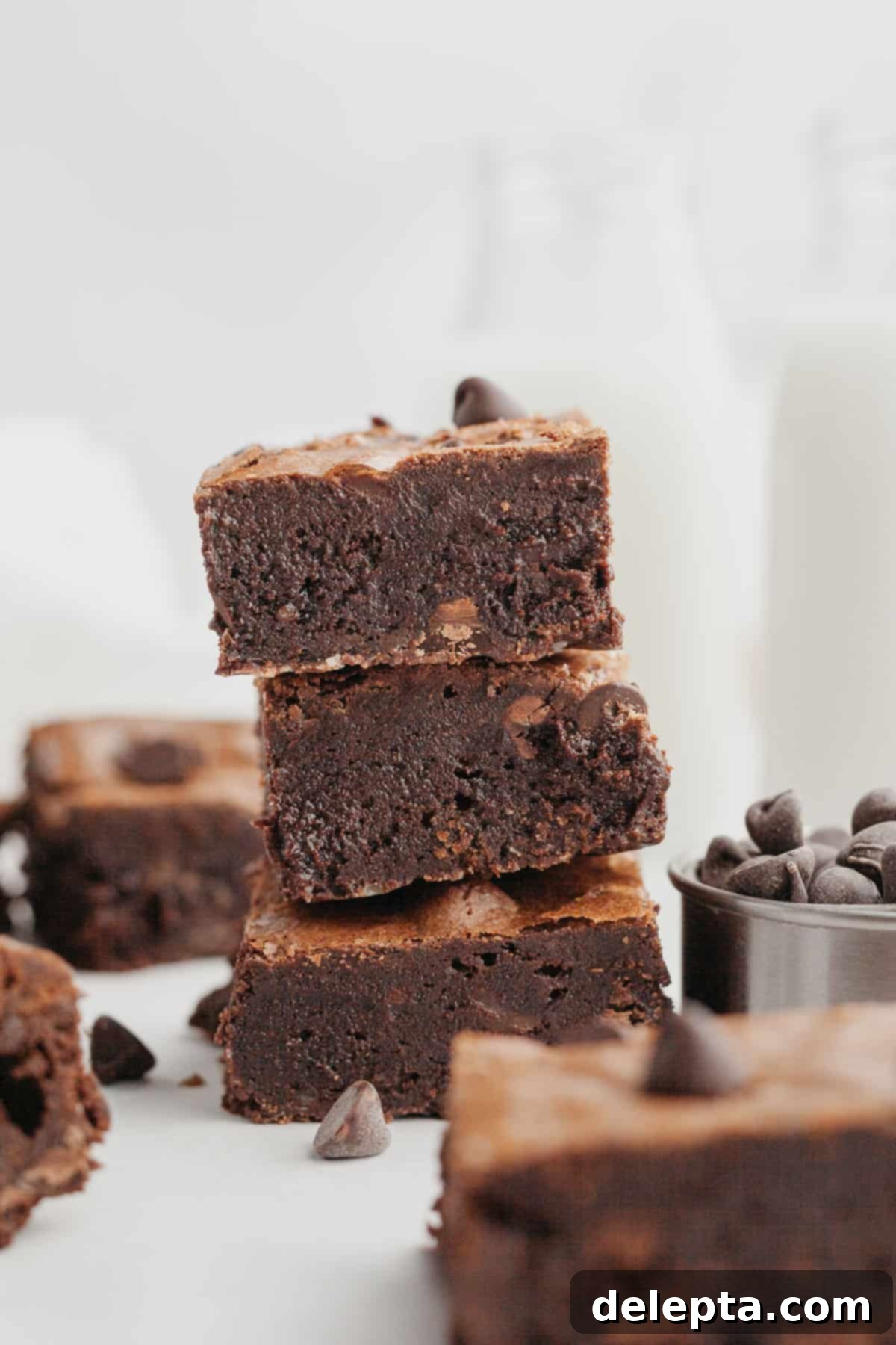 Decadent Fudgy Triple Chocolate Brownies 9 A tempting stack of three thick, fudgy triple chocolate brownies, ready to be devoured.