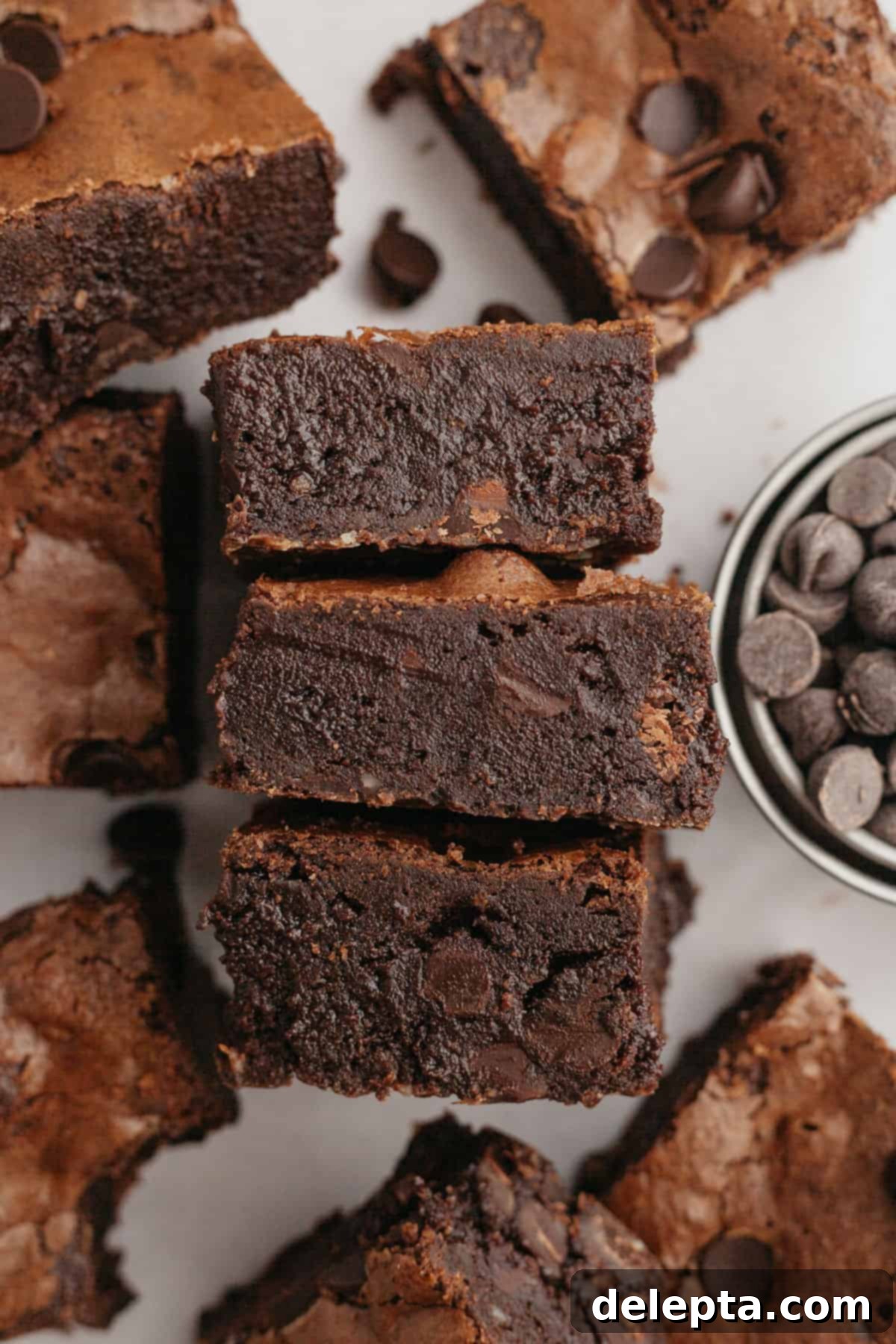 Decadent Fudgy Triple Chocolate Brownies 10 A batch of baked triple chocolate brownies cooling on parchment paper, ready to be sliced and enjoyed.
