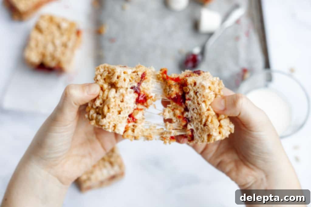 Peanut Butter Jelly Krispie Squares 5 hands pulling apart two rice krispie treats with jelly in the middle
