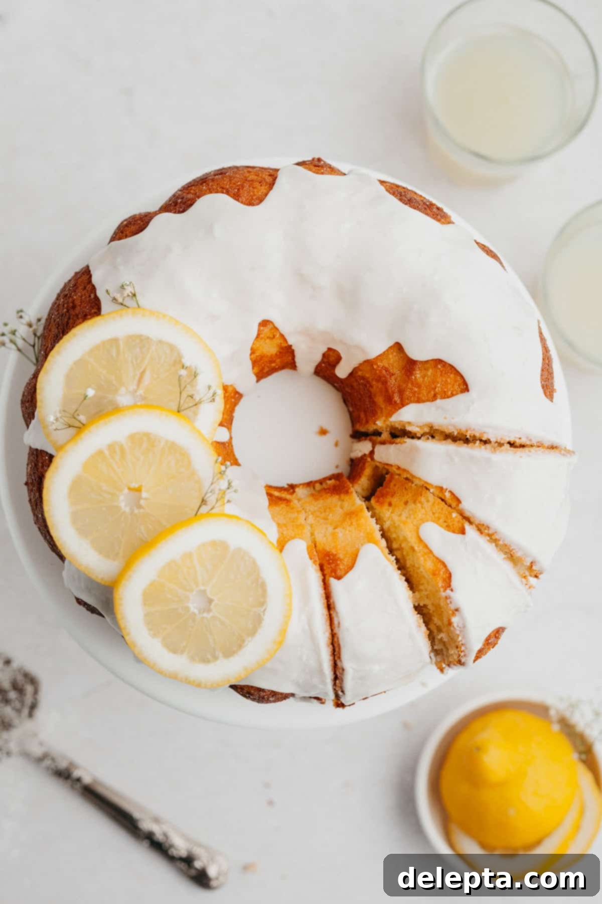 Sunny Lemon Bundt Bliss 8 An overhead shot of a delightful lemon bundt cake, elegantly topped with a white glaze and three fresh lemon slices.