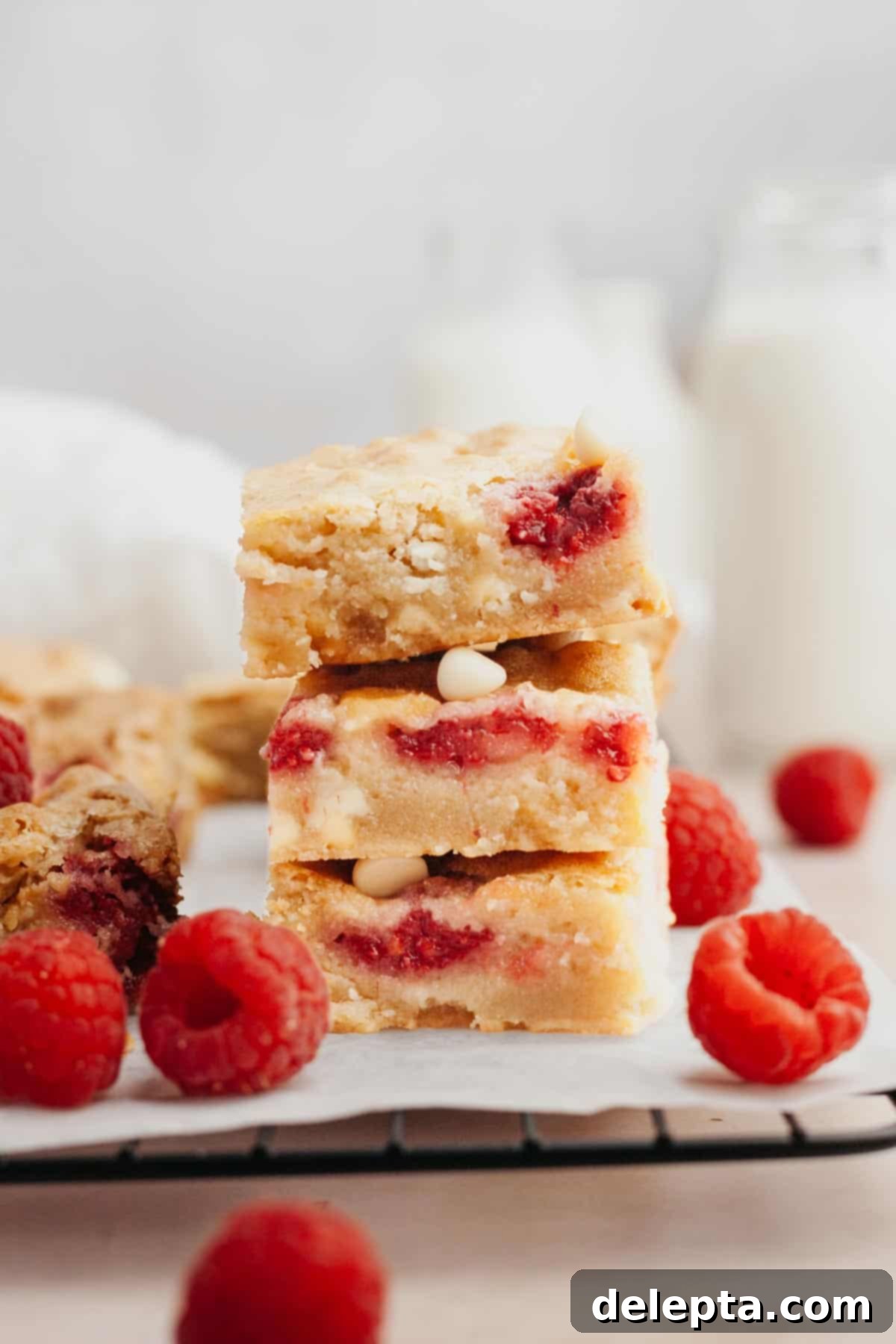 Decadent Raspberry White Chocolate Blondies 2 A stack of raspberry white chocolate blondies, showcasing their fudgy texture and delightful raspberry and white chocolate inclusions.