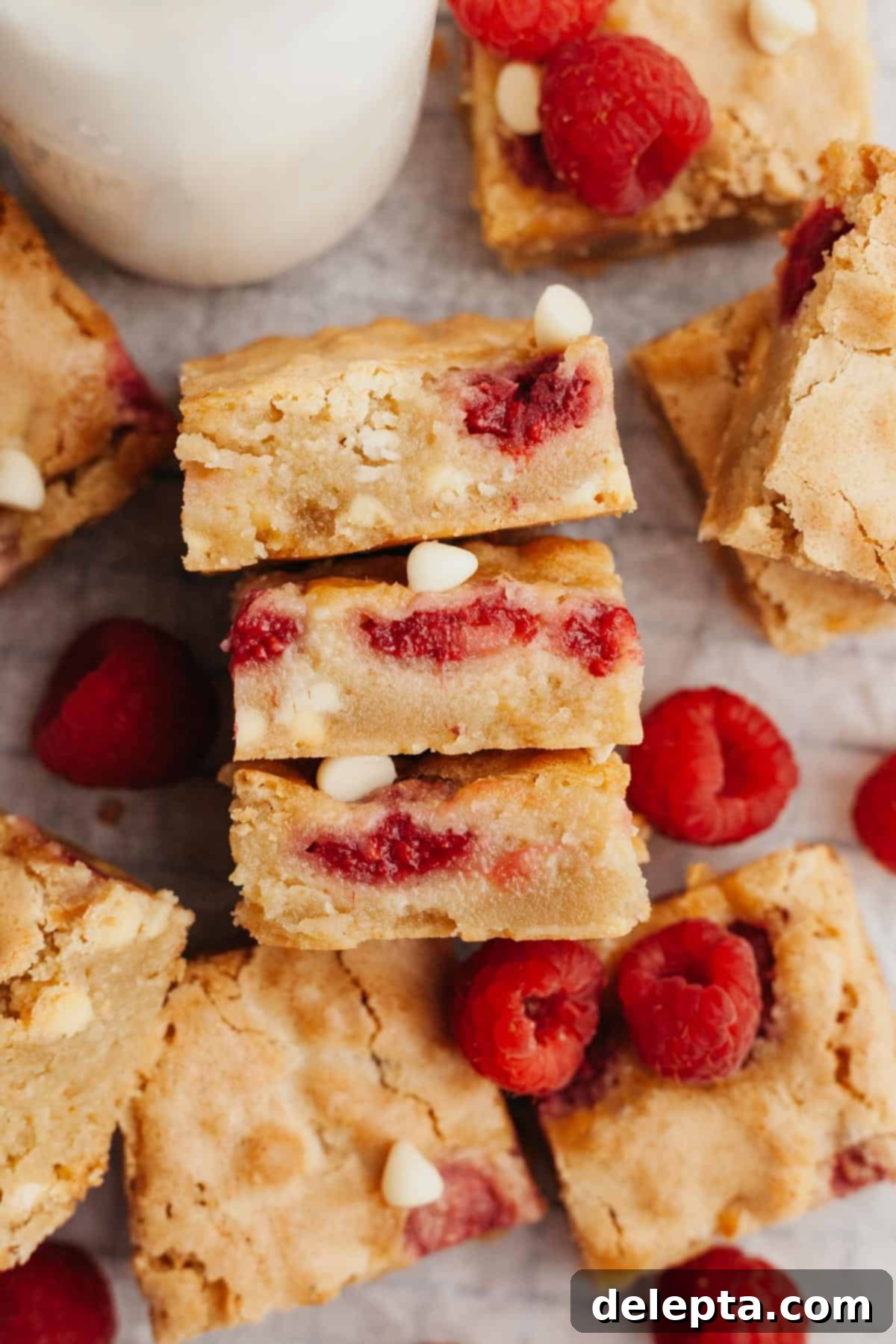 Decadent Raspberry White Chocolate Blondies 6 A stack of perfectly cut raspberry white chocolate blondies, showcasing their rich texture and vibrant inclusions.