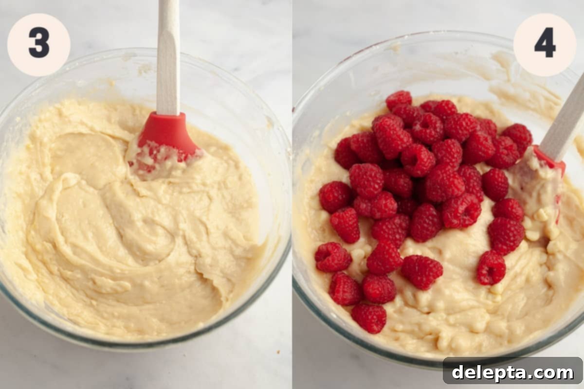 Decadent Raspberry White Chocolate Muffins 5 A glass bowl with muffin batter, raspberries, and white chocolate chips partially mixed in.
